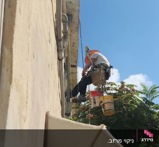 אדם בעבודות גובה עם חבלים ודליים